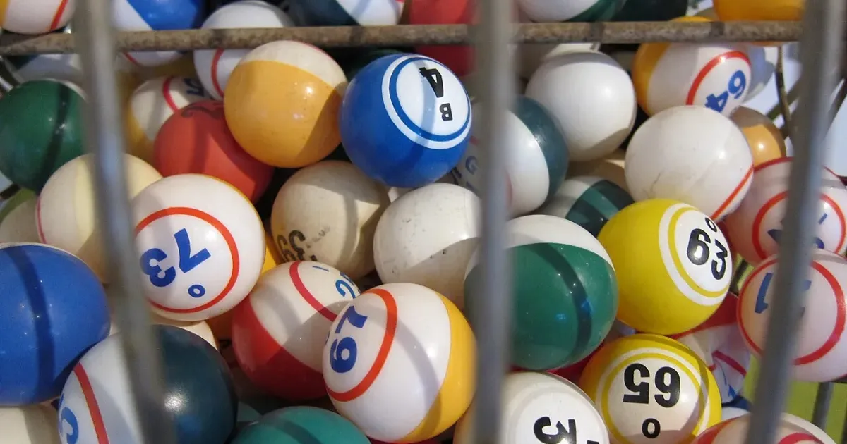 Colorful numbered bingo balls inside a wire cage drum