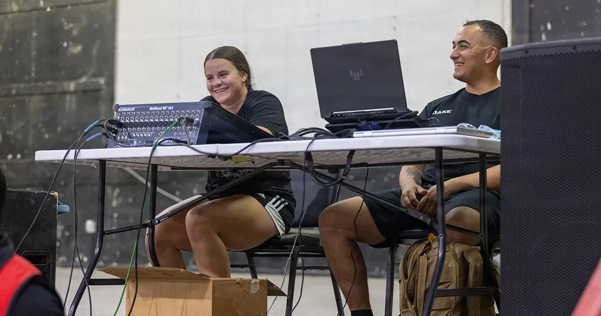 Bingo event hosts setting up laptop and sound equipment