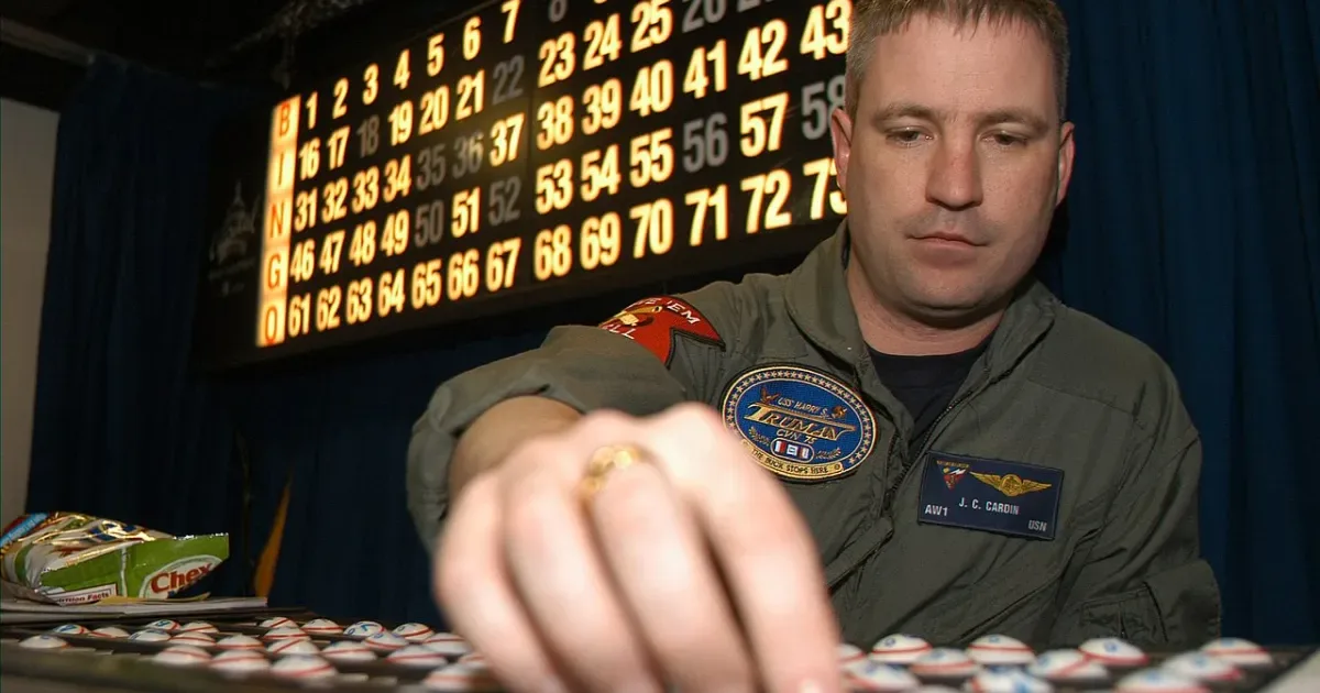 Bingo facilitator calling numbers with chips on board