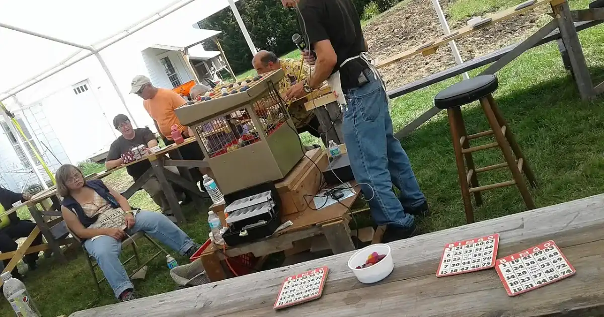 Outdoor bingo fundraiser event with cage and cards on tables