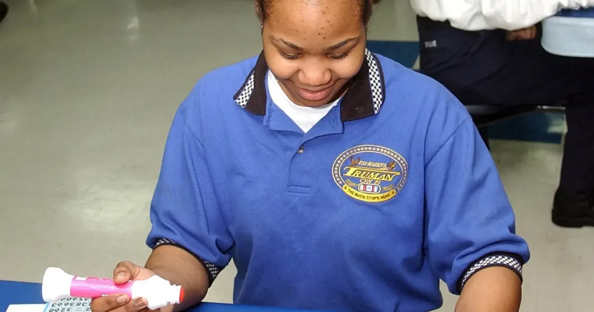 Bingo player marking numbers on bingo cards with a pink dauber