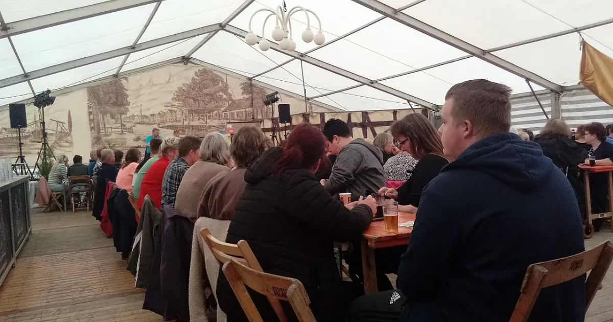 Community bingo event with crowd seated in large tent
