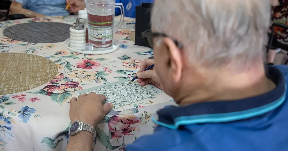 Senior citizens playing bingo at a table together